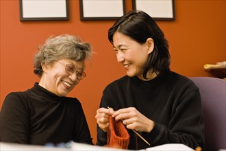 Asian mother and daughter knitting