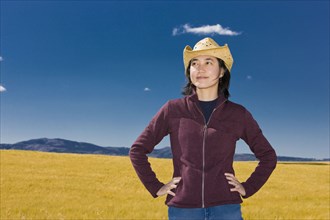 Asian woman standing in remote field