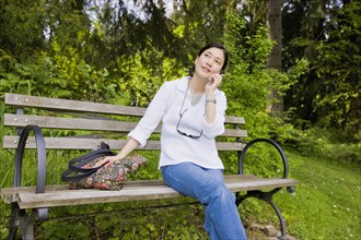 Japanese woman using cell phone in park