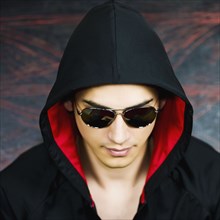 Mixed race man in hooded jacket and sunglasses