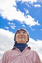 Older Japanese woman smiling outdoors