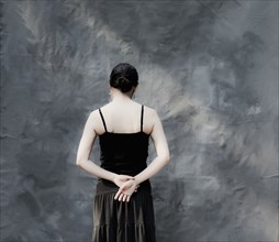 Japanese woman standing by gray curtain