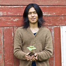 Japanese man holding potted plant outdoors