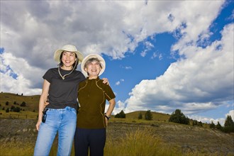 Japanese mother and daughter standing on hillside