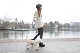 Japanese woman walking dog near lake