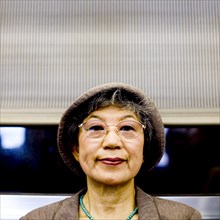 Serious Japanese woman wearing hat and eyeglasses