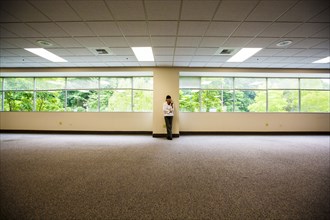 Japanese businesswoman leaning on wall of empty office