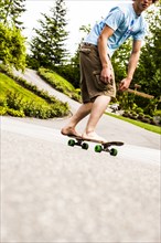 Caucasian boy skateboarding barefoot