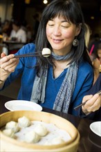 Japanese woman eating food with chopsticks