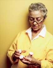 Caucasian woman examining pill bottles