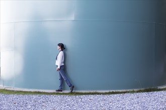 Japanese woman walking near storage tank