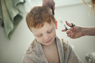 Caucasian mother giving son haircut