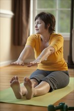 Caucasian woman stretching on exercise mat