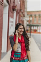 Mixed race woman talking on cell phone on city street