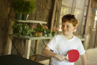 Caucasian boy playing table tennis