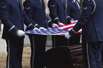 Soldiers folding flag at military funeral