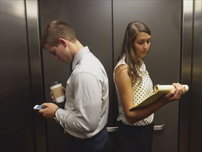 Business people ignoring each other in elevator