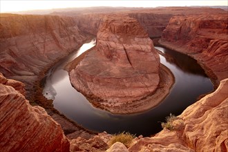 Horse shoe bend in river near majestic rock formations in desert landscape