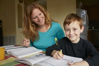 Caucasian mother helping son do homework
