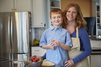 Caucasian mother and son cooking in kitchen