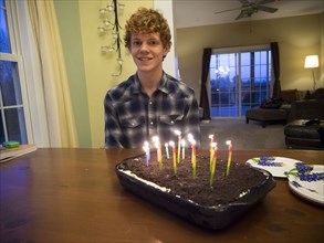 Caucasian boy smiling with birthday cake