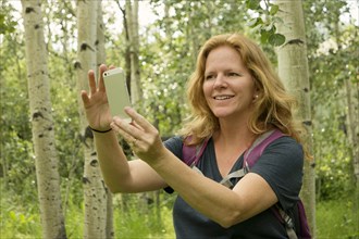 Caucasian woman taking self-portrait in forest