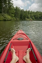 Caucasian teenage boy sitting in canoe on lake