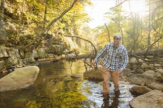 Caucasian man walking in forest stream