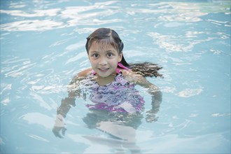 Smiling Hispanic girl in swimming pool