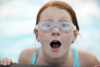 Portrait of surprised Caucasian girl wearing swimming goggles