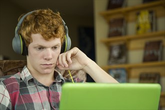 Caucasian boy listening to laptop with headphones