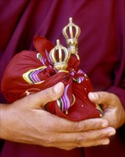 Close up of hands holding ceremonial bells