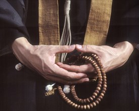 Close up of hands holding Buddhist prayer beads
