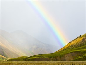 Rainbow over rural fields and hillside