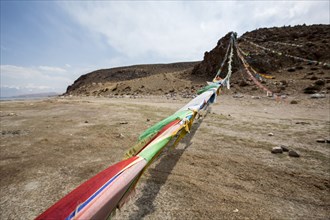 Prayer flags blowing in wind in remote field