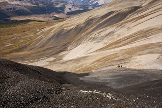 Distant view of hikers walking on remote hillside