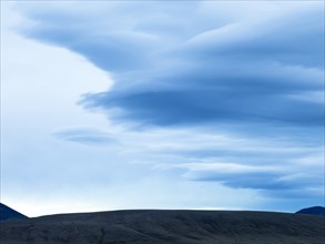 Silhouette of mountain range under cloudy sky