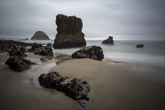 Rock formations and ocean waves on sandy beach