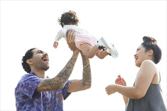 Parents playing with baby son outdoors