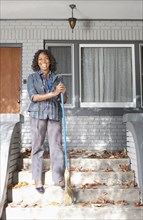 Black woman sweeping front stoop steps