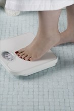 Woman stepping onto bathroom scale