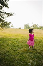 Black baby girl standing in park