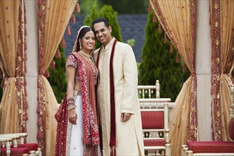 Smiling Indian couple in traditional wedding clothing