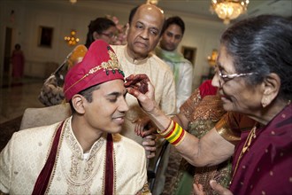 Indian woman marking groom's face