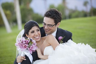 Newlywed couple hugging on golf course