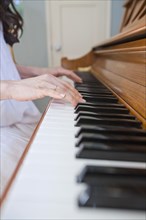 Close up of mixed race woman playing piano