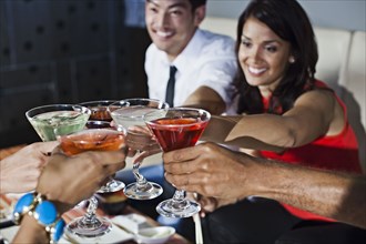 Friends toasting with cocktails in nightclub