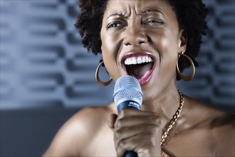 African American woman singing karaoke in nightclub