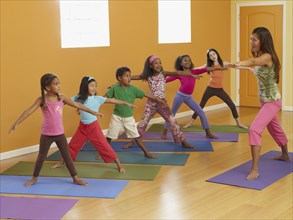 Teacher leading class of children in exercise routine