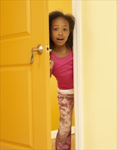 Surprised African girl opening door